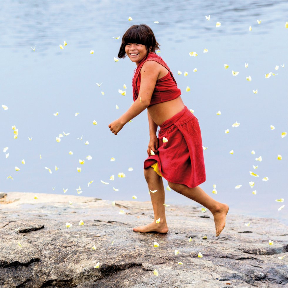 Una mujer araweté, Brasil, sonríe envuelta en mariposas, en 2012. El araweté es un pueblo indígena de Brasil. Son un pueblo tupí-guaraní de cazadores y agricultores del bosque de tierra firme y en 2014 quedaban unos 467, según el Gobierno de Brasil. ALICE KOHLER SURVIVAL INTERNATIONAL